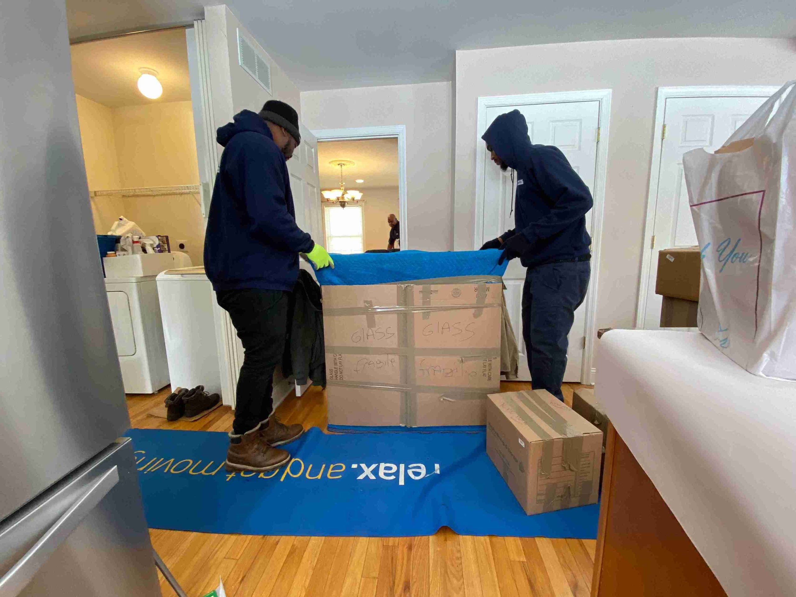 two workers carefully moving the package