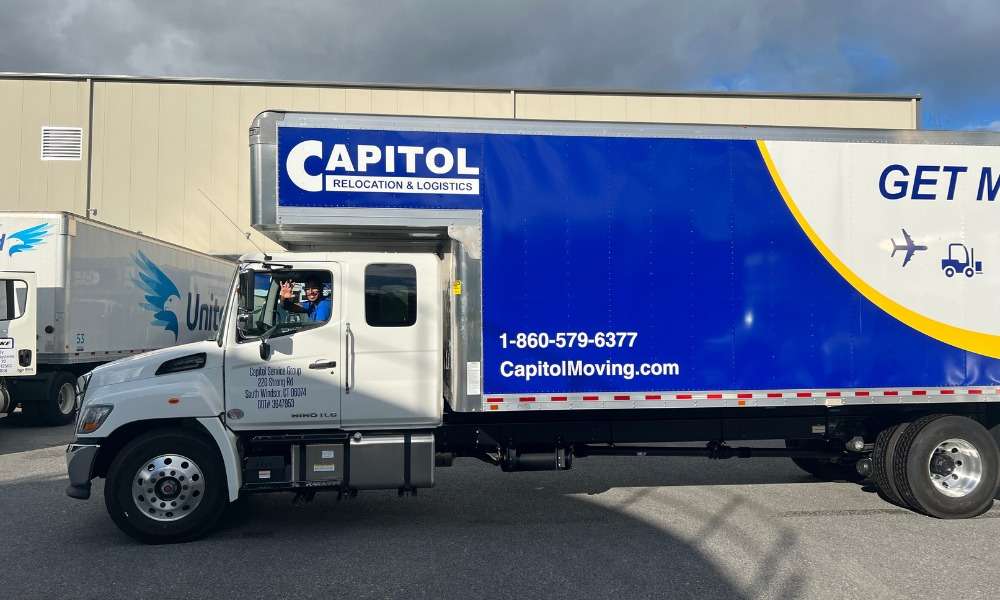 Side view of a blue and white Capitol moving truck